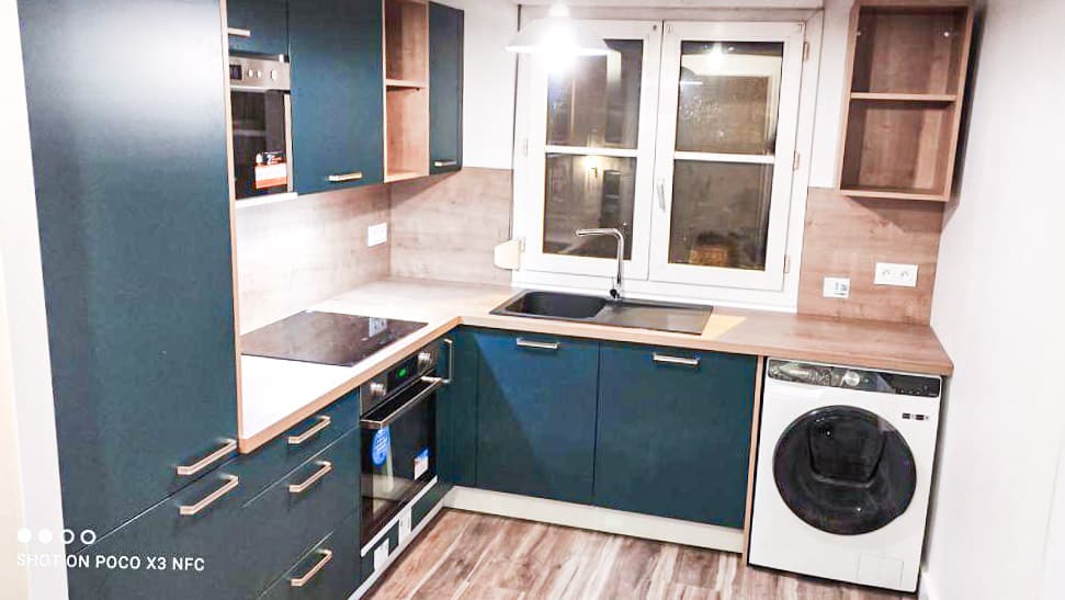 Cuisine Moderne Bleu Sarcelle et Bois Neuf Cuisine moderne bleu sarcelle et bois clair, avec plaque induction, four encastré, évier noir, fenêtre et lave-linge. Texte visible : SHOT ON POCO X3 NFC.